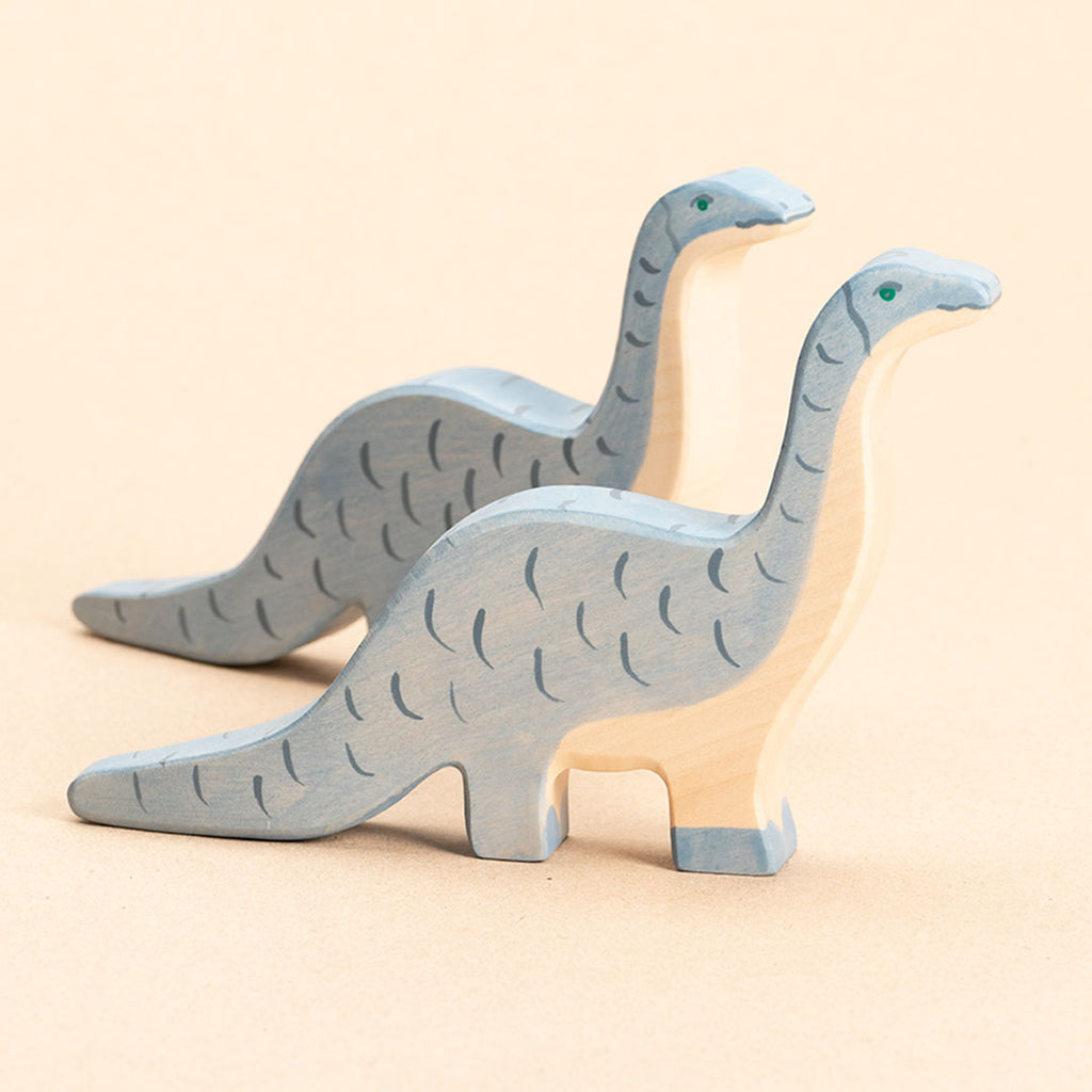 Zwei Brontosaurus aus Holz. Blau bemalt mit dunkelblauen Strichen. Beide nach rechts schauend.