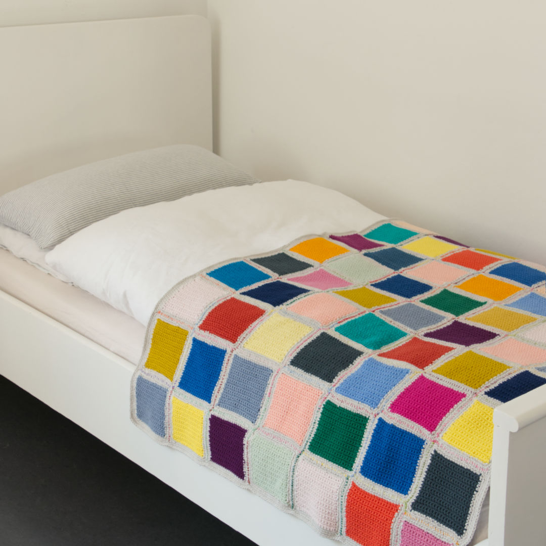 Bunte, gehäkelte Decke als Tagesdecke