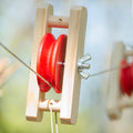 Detail Flaschenzug Rolle aus Holz in rot und naturfarben mit Hanfschnur