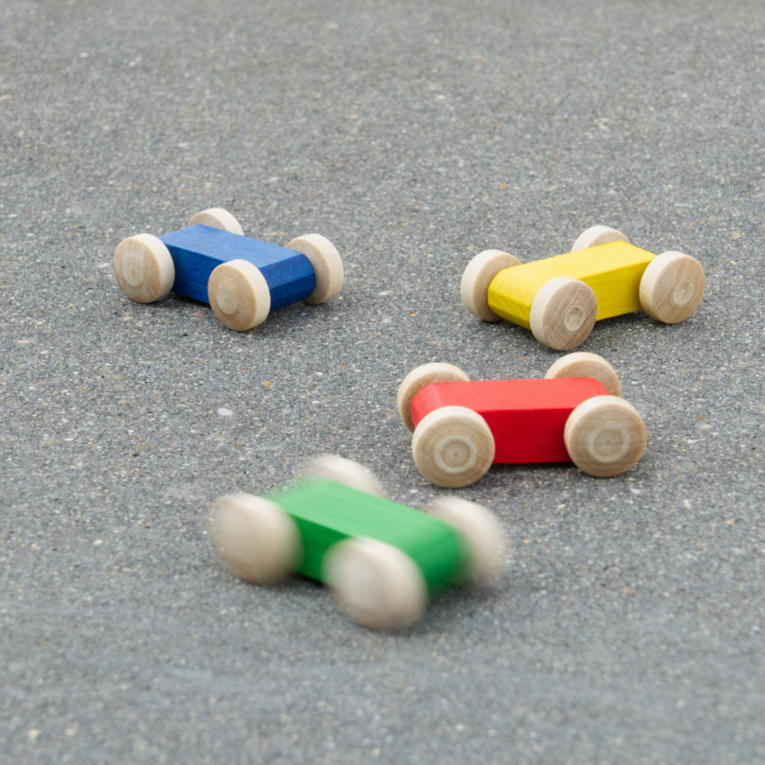 Komposition aus kleinen Holzfahrzeug-Flitzern in bunten Farben