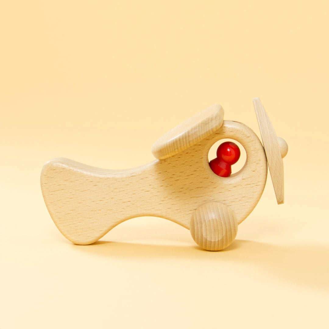 Holz-Flugzeug aus naturbelassenem Buchenholz und roter Holz-Figur