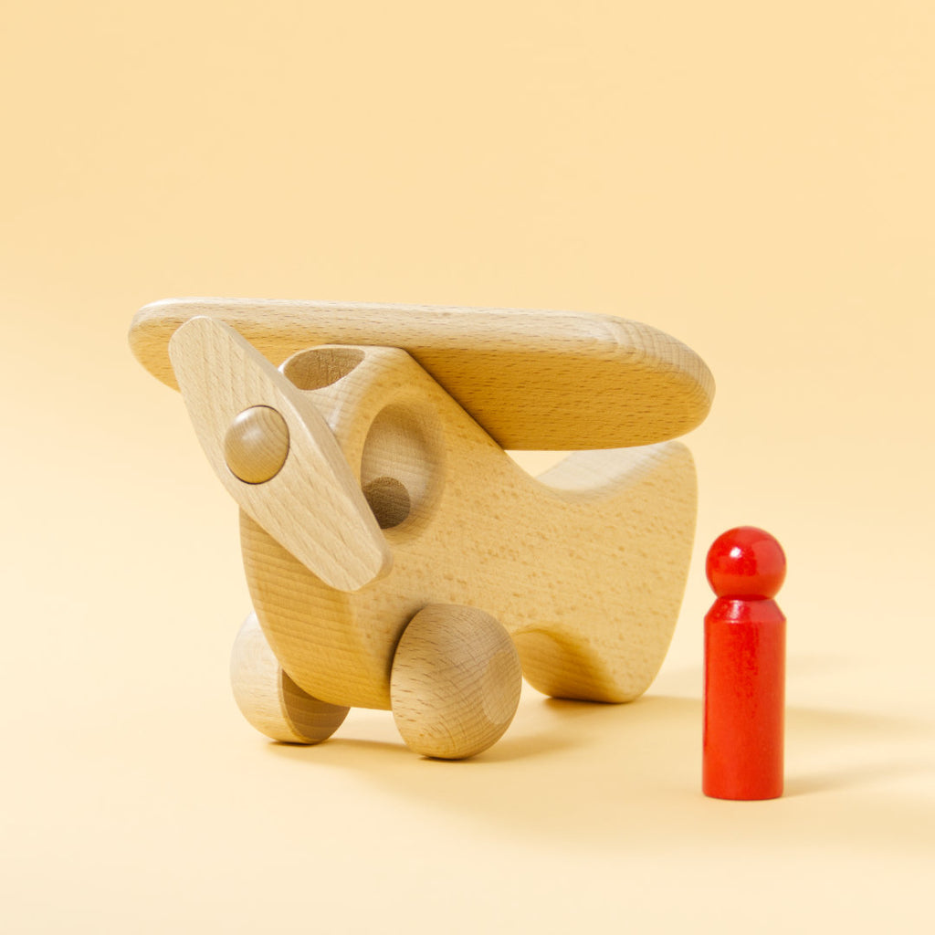 Holz-Flugzeug aus naturbelassenem Buchenholz und roter Holz-Figur