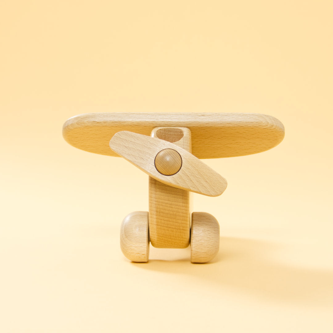 Holz-Flugzeug aus naturbelassenem Buchenholz und roter Holz-Figur