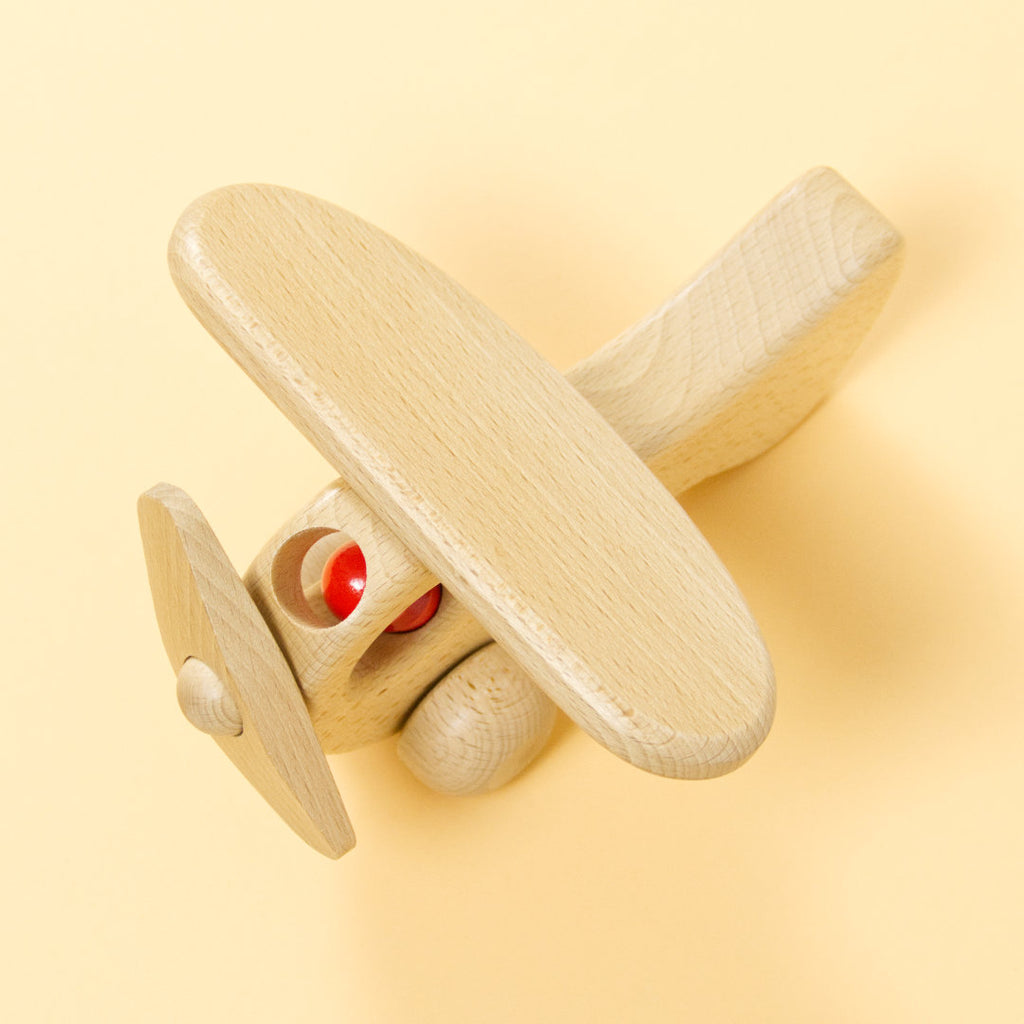 Holz-Flugzeug aus naturbelassenem Buchenholz und roter Holz-Figur