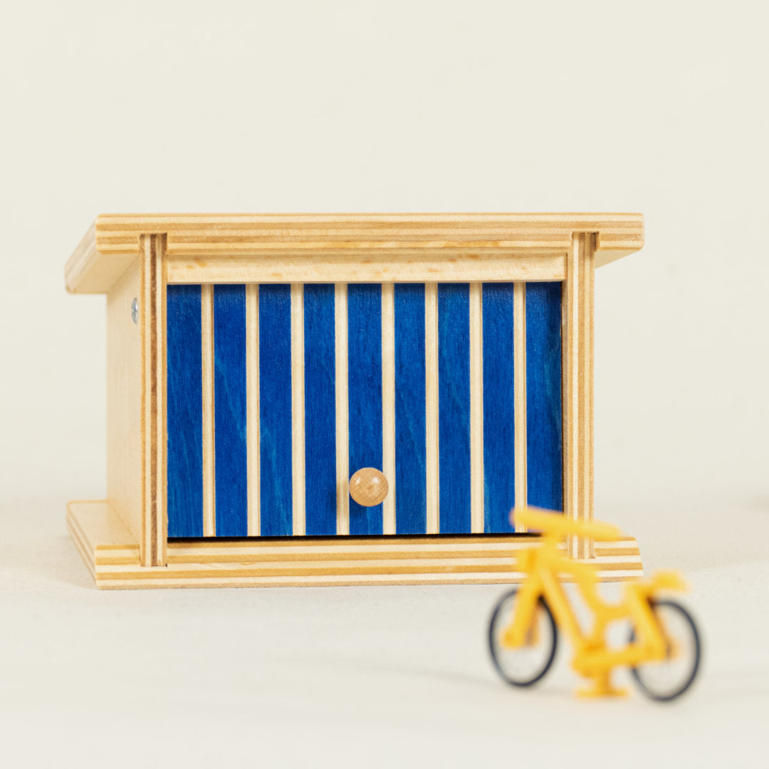 Garage aus Holz mit blau-gestreiftem Kipptor
