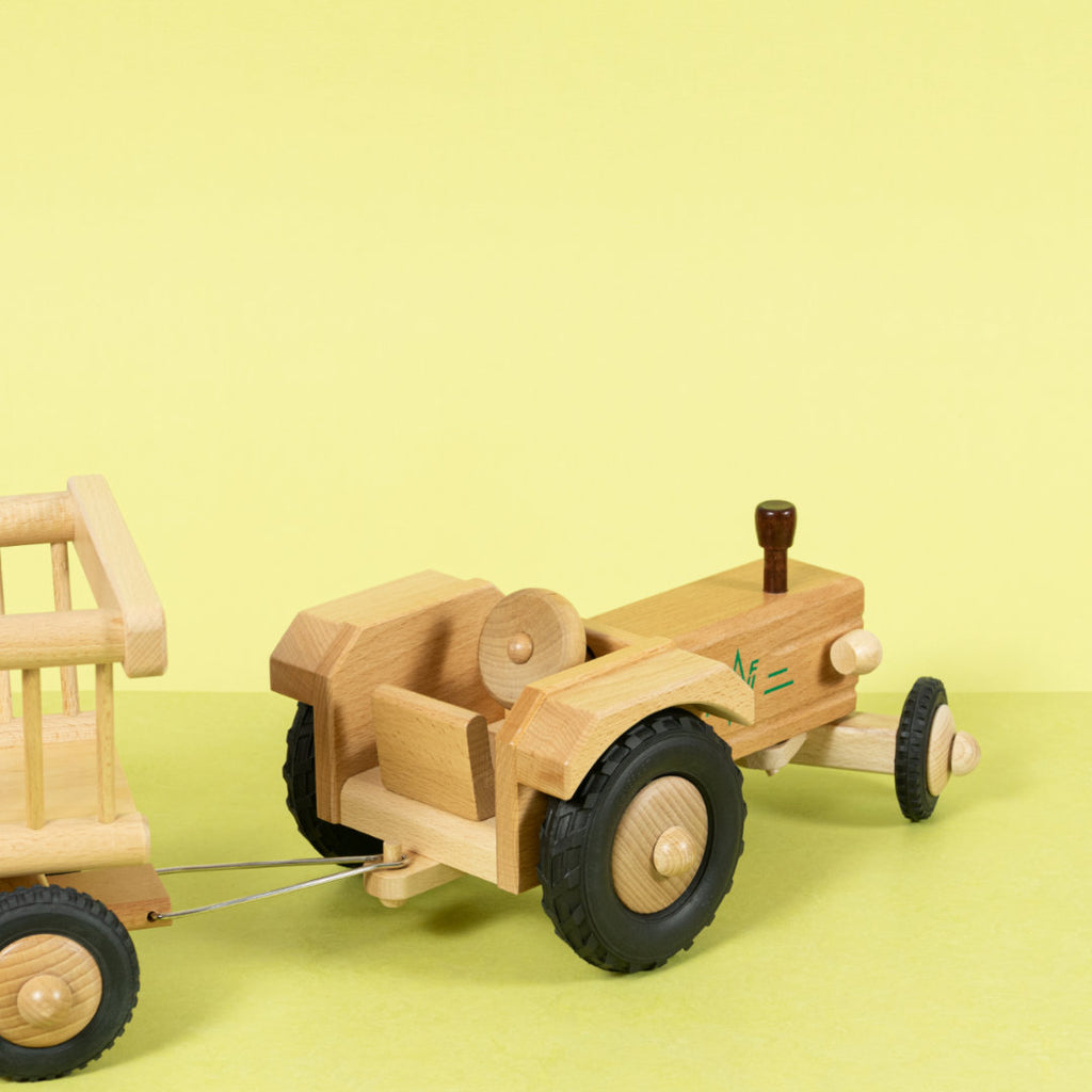 Holztraktor aus naturfarbenem Buchenholz mit dunkel lackierten Details und Anhängerkupplung