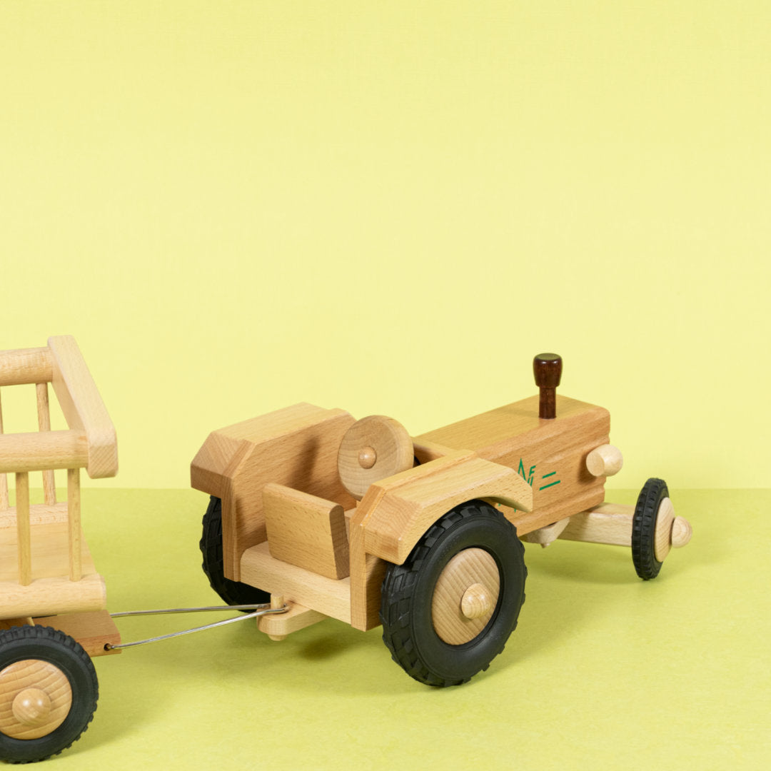 Holztraktor aus naturfarbenem Buchenholz mit dunkel lackierten Details und Anhängerkupplung