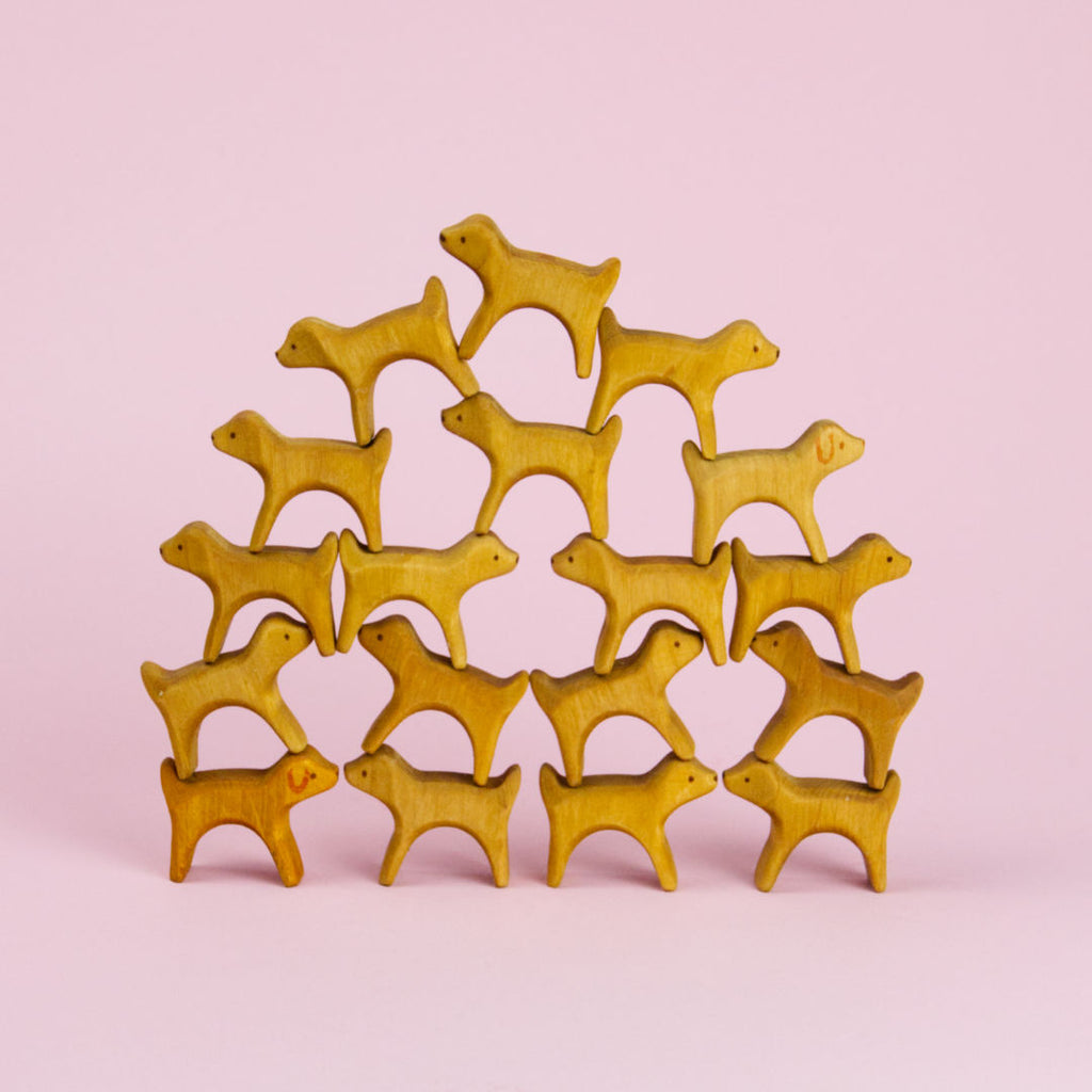 Kleine Hunde aus Holz bauen eine Pyramide