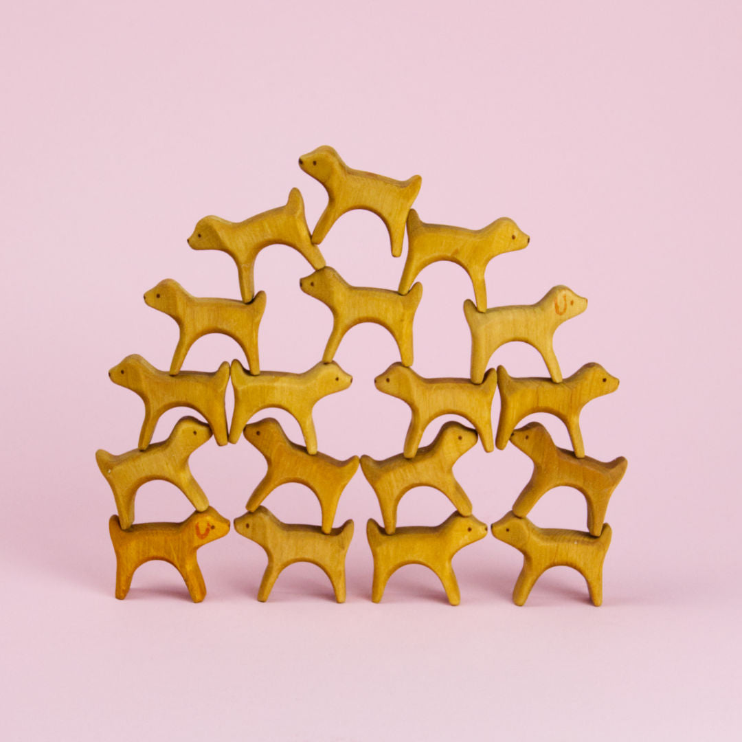 Kleine Hunde aus Holz bauen eine Pyramide