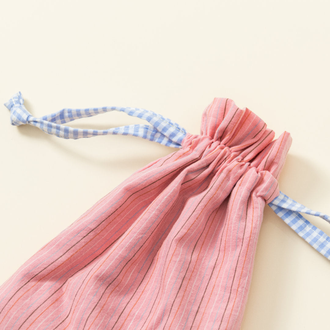 Hand-genähtes Murmelsäckchen mit Streifen-Muster in Rosa außen und gepunktet in Beige-Schwarz innen, geschlossen, inklusive einem individuellem Set aus einer großen Glas-Murmel und zwölf kleinen Glas-Murmeln, Detailaufnahme Bund Säckchen