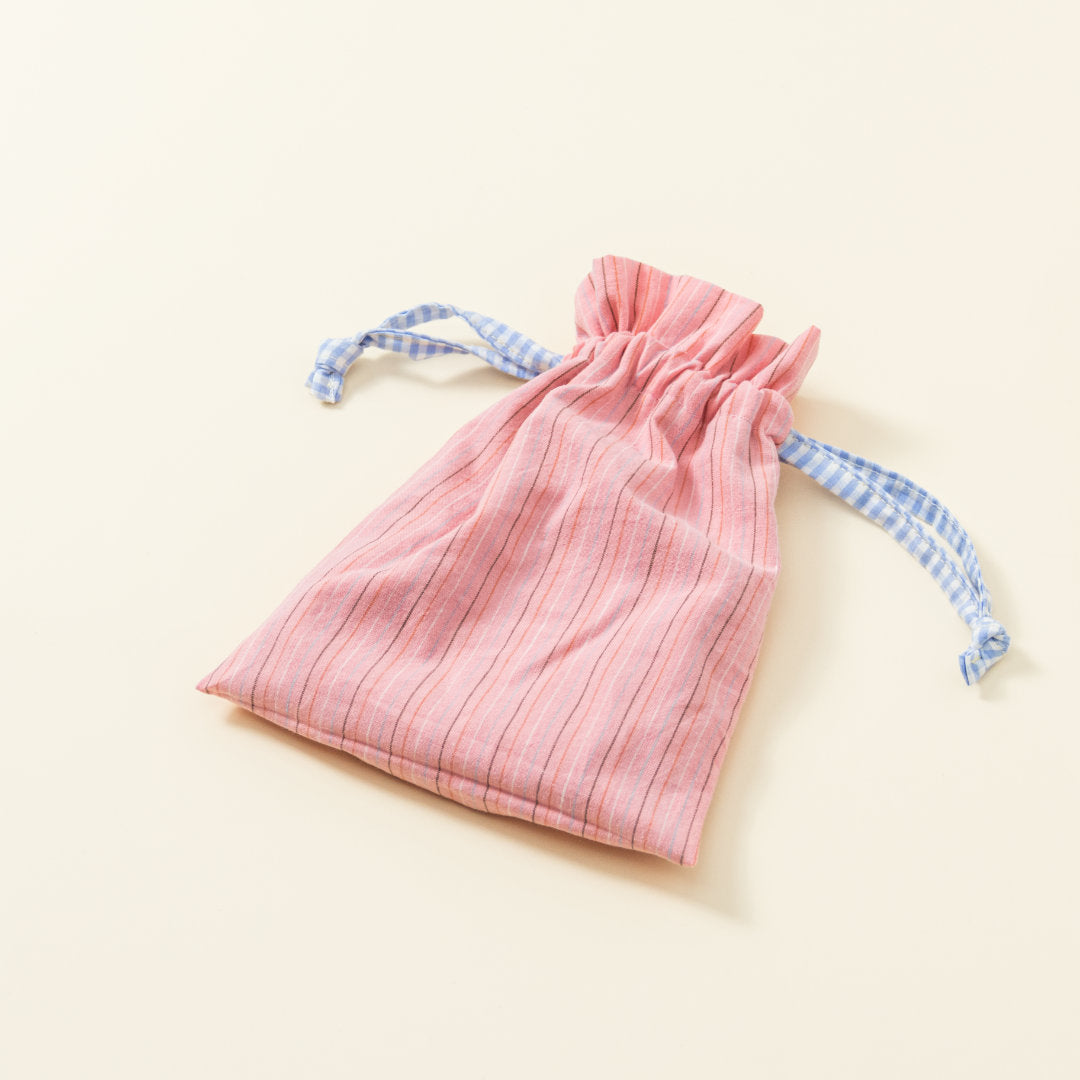 Hand-genähtes Murmelsäckchen mit Streifen-Muster in Rosa außen und gepunktet in Beige-Schwarz innen, geschlossen, inklusive einem individuellem Set aus einer großen Glas-Murmel und zwölf kleinen Glas-Murmeln