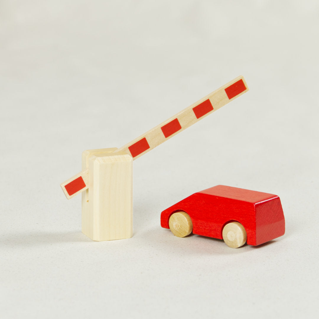 Bewegliche Bahnschranke naturlackiert aus Ahornholz mit roten Streifen geöffnet mit rotem Holzvan