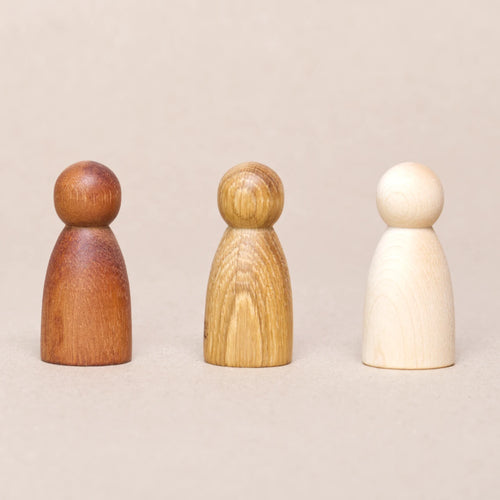 Drei Holzfiguren in drei unterschiedlichen Holzarten von Grapat. Rechts in weiß Natur, in der Mitte in hellbraun Natur und links dunkelbraun Natur.