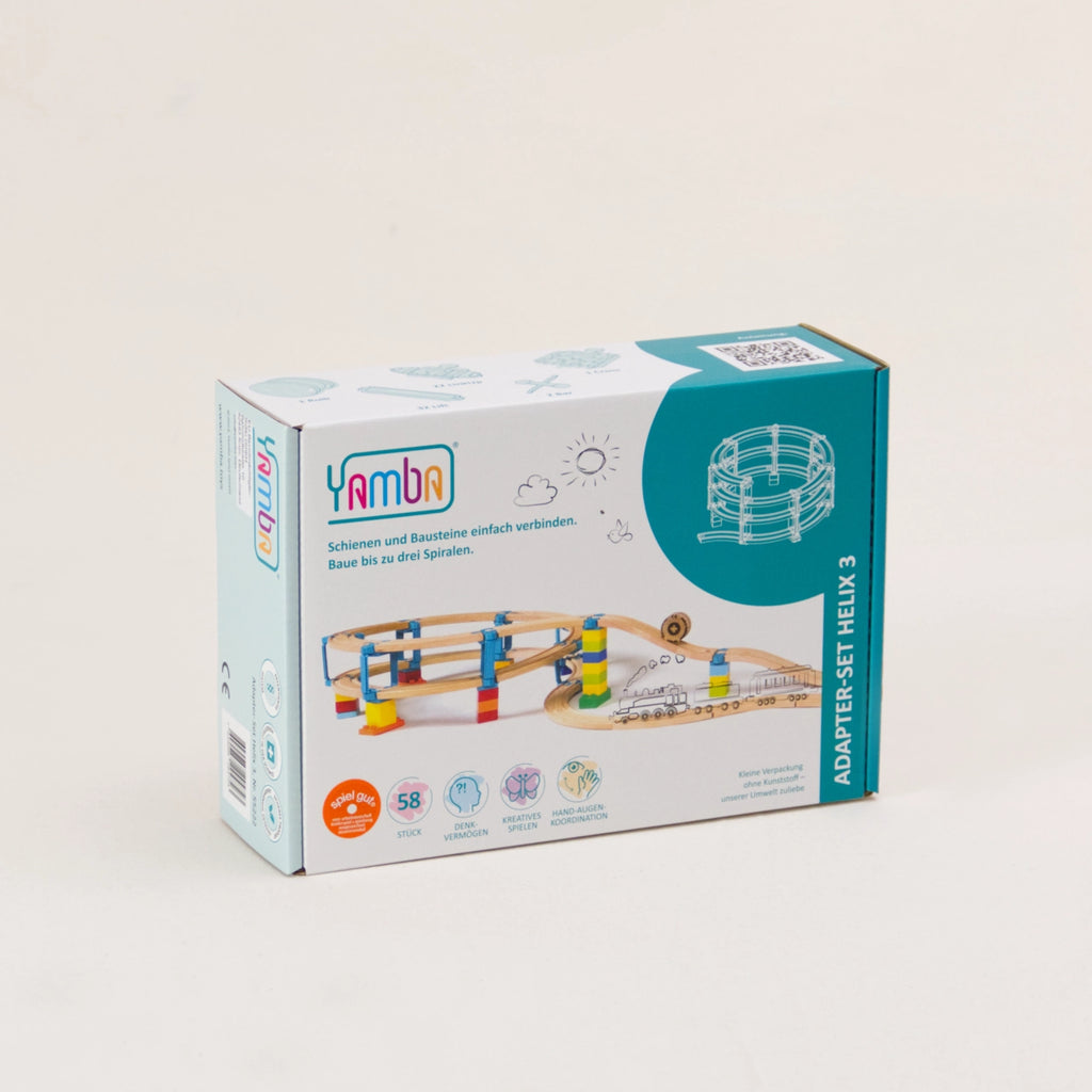 Zu sehen ist die Verpackung des Adapter-Sets Helix 3 von Yamba. Die rechteckige Pappverpackung ist weiß und türkis mit bunten Details und zeigt einen möglichen Aufbau. Die Verbindungselemente ergeben zusammen mit Klemmbausteinen (DUPLO®, BioBUDDi®, Hubelino® usw.) und Schienen (BRIO®, IKEA®, Eichhorn®, Hape® usw.) ein mehrstöckiges Säulensystem. Helix 3 ist die mittlere Größe und ermöglicht vier Schleifen nach oben.