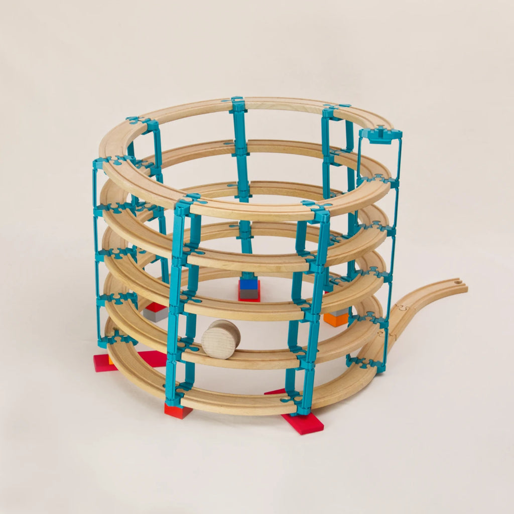 Das Adapter-Set Helix 5 von Yamba ermöglicht die Kombination von Klemmbausteinen (DUPLO®, BioBUDDi®, Hubelino® usw.) und Schienen (BRIO®, IKEA®, Eichhorn®, Hape® usw.) zu einem Säulensystem über mehrere Ebenen. Das Set enthält 104 Elemente und ermöglicht bis zu sechs Stockwerke. Es gibt fünf Bauelemente: Link, LinkUp, Cross, Lift und Bar. Zusätzlich enthält es die Holzwalze „Rolli“, die selbstständig nach unten rollt, ohne zu entgleisen.
