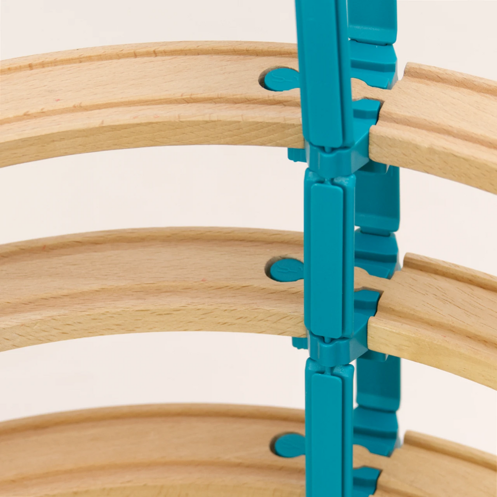 Das Adapter Set Helix 5 von Yamba ist aufgebaut in einem Detail Ausschnitt zu sehen. 3 Ebenen von Holzschienen sind jeweils durch ein Verbindungsstück LinkUp verbunden und seitlich von diesem Verbindungsstück gehen zwei Säuleelemente Lift nach oben und unten, damit kann man mehrere Etagen der Bahn übereinander bauen.