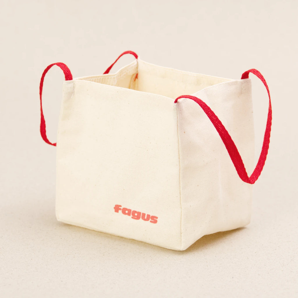 Ein Big Bag von fagus aus heller Baumwolle mit zwei roten Henkeln. Er hat das fagus Logo in rot auf die Vorderseite aufgedruckt.