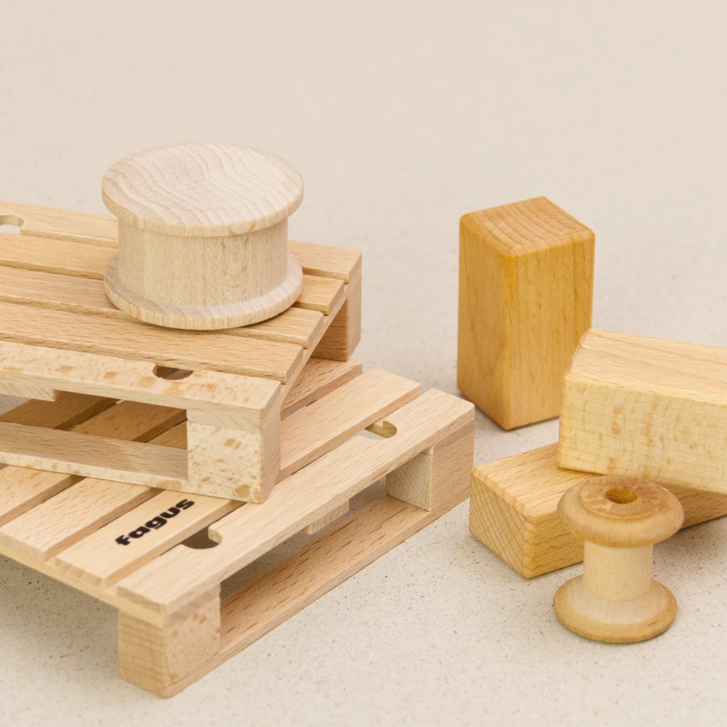 Europalette von fagus aus naturlackiertem Buchenholz. Zwei Paletten stehen schräg aufeinander und werden mit Rollen und Blöcken beladen.