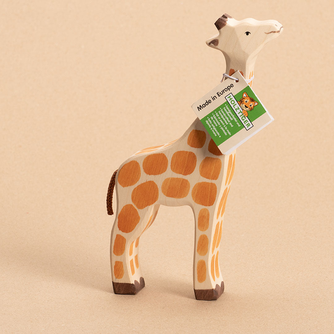 Giraffe aus Holz, bemalt. Nach rechts schauend mit Holztiger Etikett