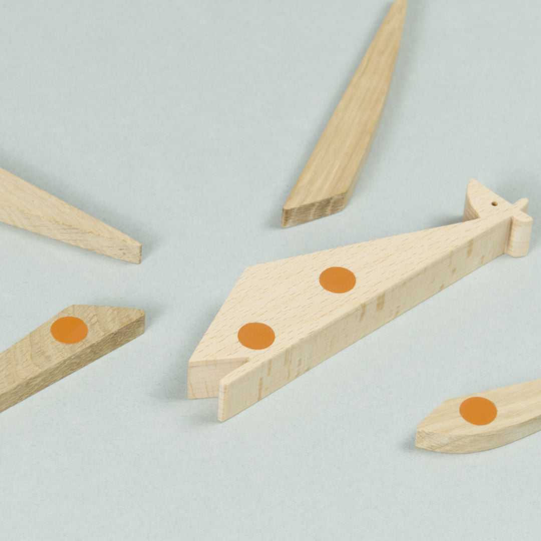 Einzelteile des Giraffen Puzzles aus Holz, magnetische Punkte sind orange markiert.