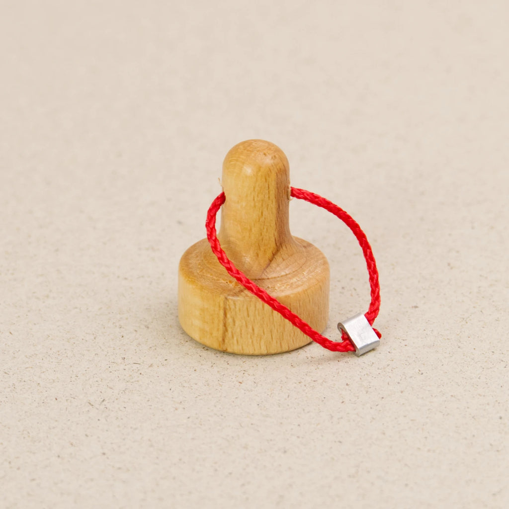 Hebemagnet von fagus aus naturlackiertem Buchenholz mit roter Verbindungsschnur.