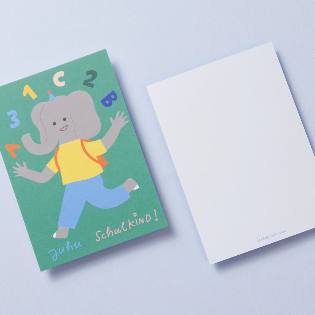Ein fröhliches Elefantenkind in blauer Hose, gelbem T-Shirt und mit rotem Schulranzen läuft seinem ersten Schultag entgegen. Über ihm tanzen die bunten Zeichen 1, 2, 3 und ABC. Auf grünem Hintergrund steht „Juhu Schulkind“ in Handschrift. Das Bild zeigt Vorder- und Rückseite der Postkarte. Die weiße Rückseite trägt unten den Schriftzug der Illustratorin.