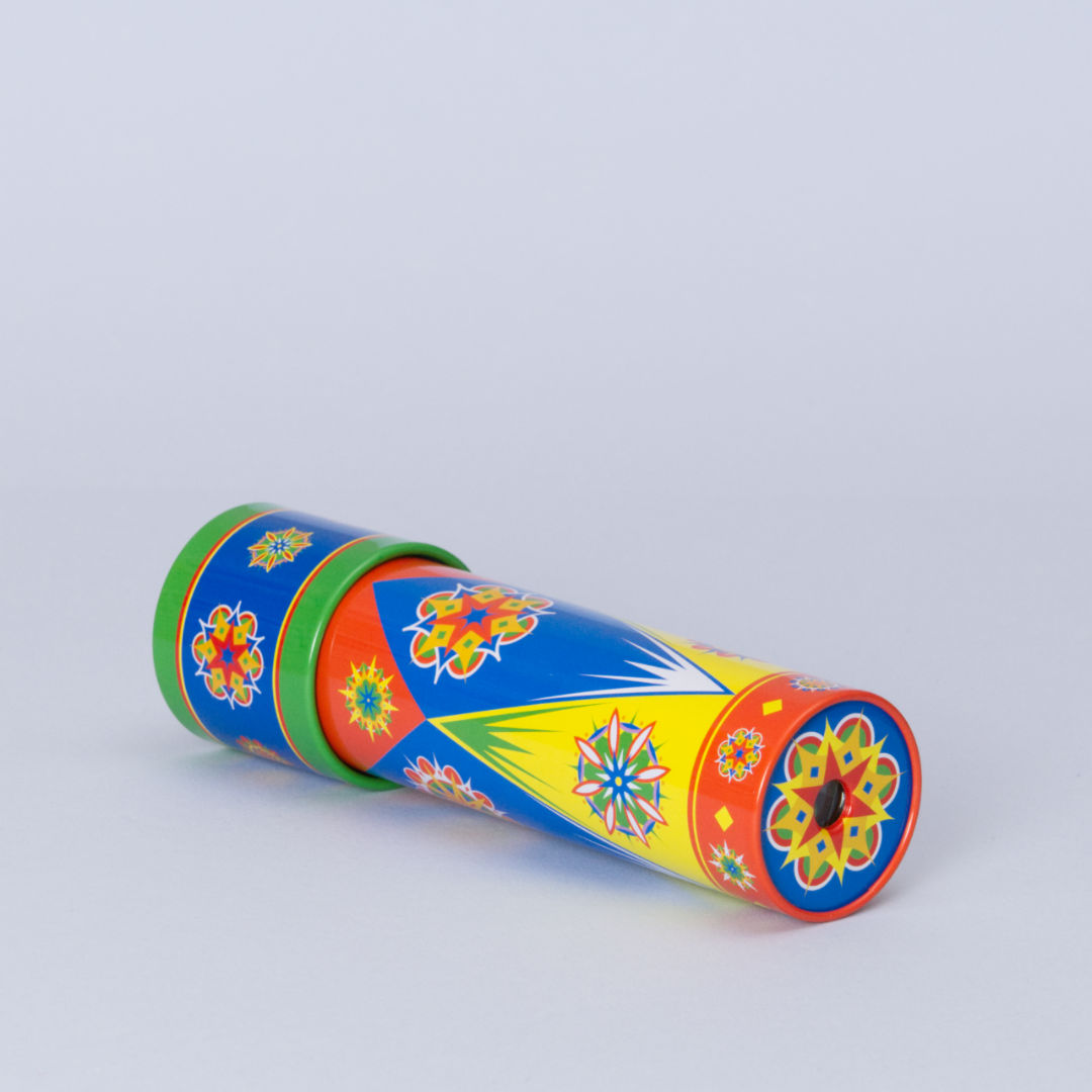 Buntes Kaleidoskop aus Metall mit Drehmechanismus von der Marke Goki.Das bunte Metallrohr ist liegend zu sehen und das Guckloch ist auf flachen Seite des Zylinders umrahmt von einem bunten Muster.