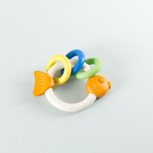Antibakterielles Babyspielzeug Rasselring in Fischoptik. Drei kleine Ringe schmücken den großen Rassel Ring in Gelb, Blau und Grün.