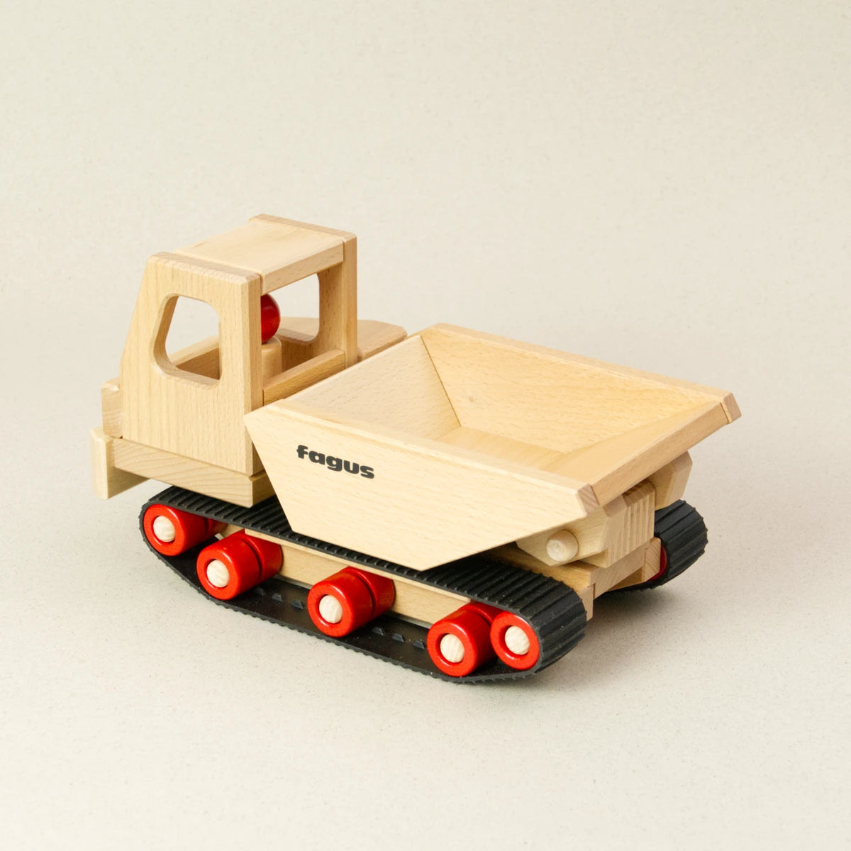 Der fagus Raupen Dumper ist aus naturbelassenem Buchenholz, hat eine kantige Lademulde und fährt auf Gummiketten. Ansicht von hinten, in die gewinkelt geschnittene Ladefläche.