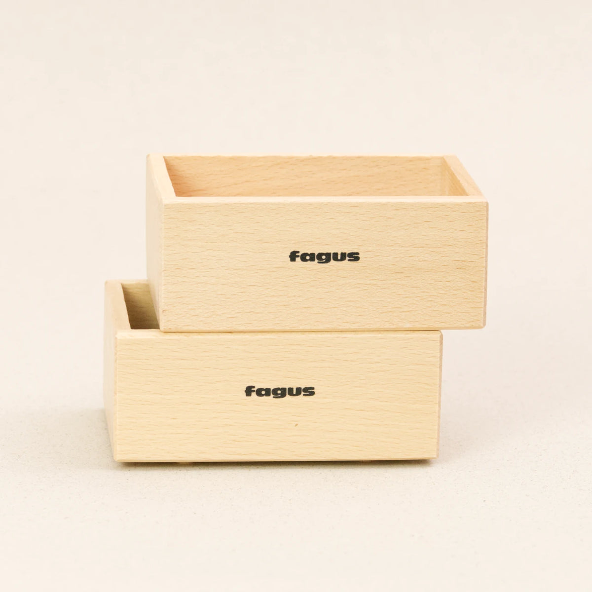 Zwei Stapelboxen von fagus aus naturlackiertem Buchenholz stehen versetzt aufeinander. Sie haben das fagus Logo auf der längeren Seite.