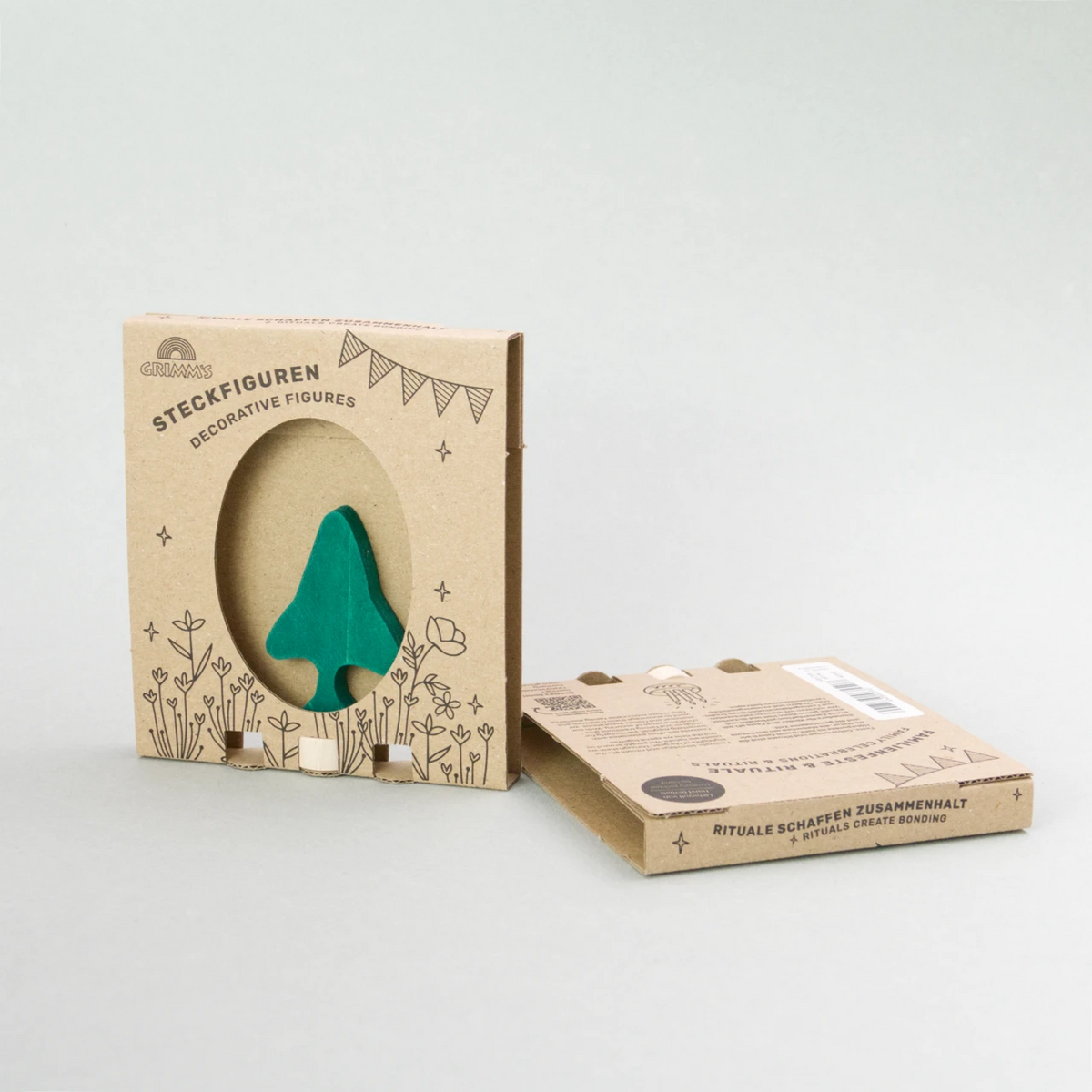 Steckfigur von Grimms aus Holz für einen Steckring, eine Tanne in dunkelgrün von vorne in der Verpackung.