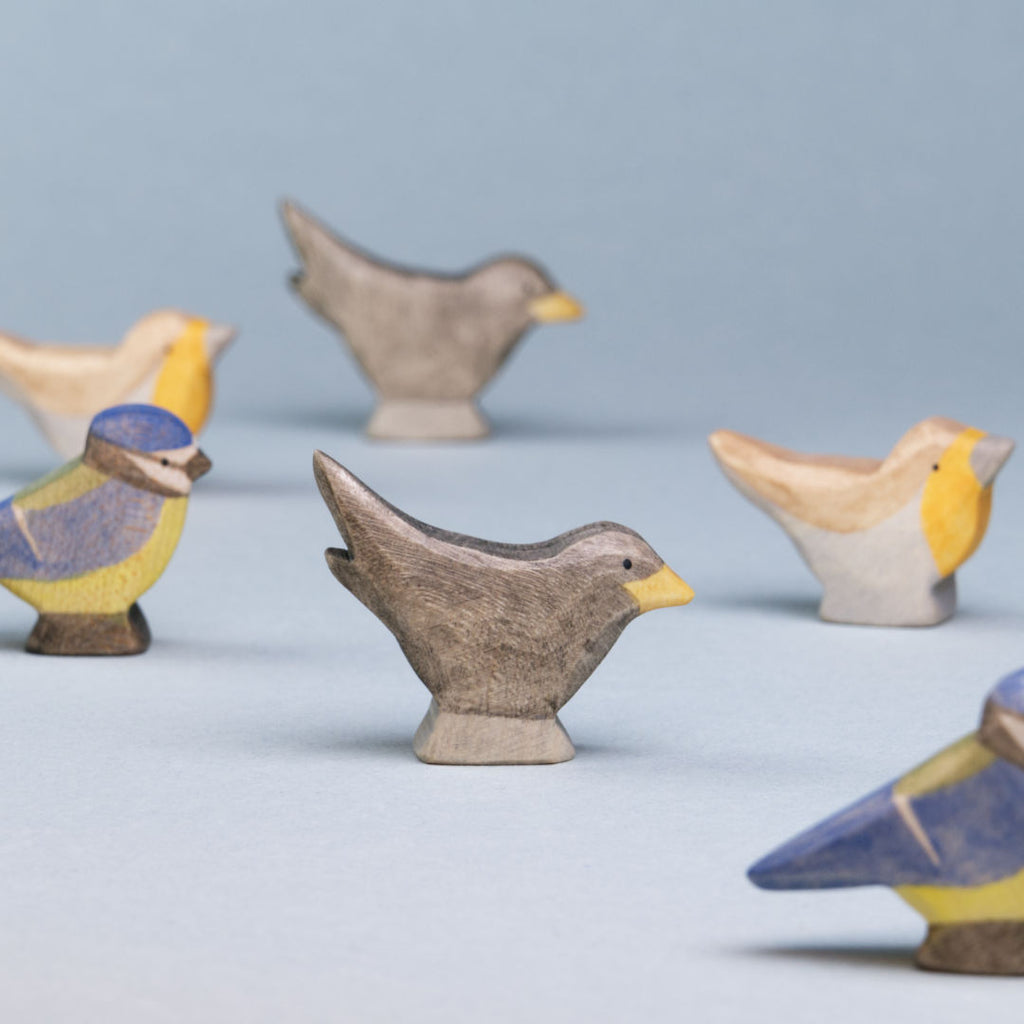 Komposition aus Holzvögeln der Firma Holzviecherl. Im Mittelpunkt Amsel, umspielt von Rotkelchen und Blaumeise.l