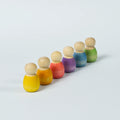 sechs kleine Babyholzfiguren in verschiedenen Farben in eine Reihe aufgestellt.