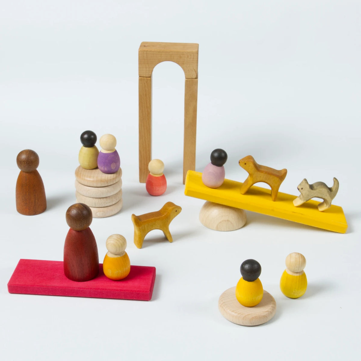 Komposition aus großen und kleinen Holzfiguren mit verschiedenen Hautfarben. Dazu verschiedene Holzelemente.