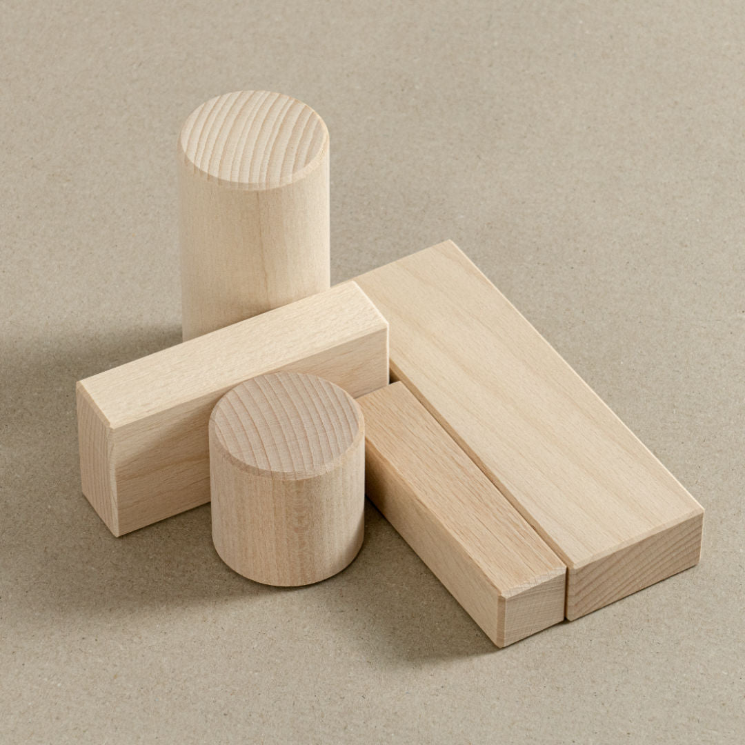 Liegende Bausteine und stehende Zylinder, beide aus Holz.