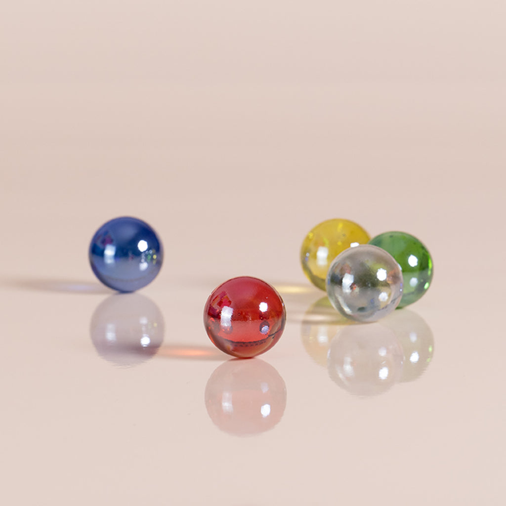 Vier Glasmurmeln in den Farben rot, blau, durchsichtig, gelb und grün von Cuboro.