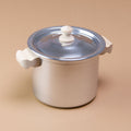 Ein Henkeltopf aus Aluminium hat Holzgriffe und einen Durchmesser von 10 cm.