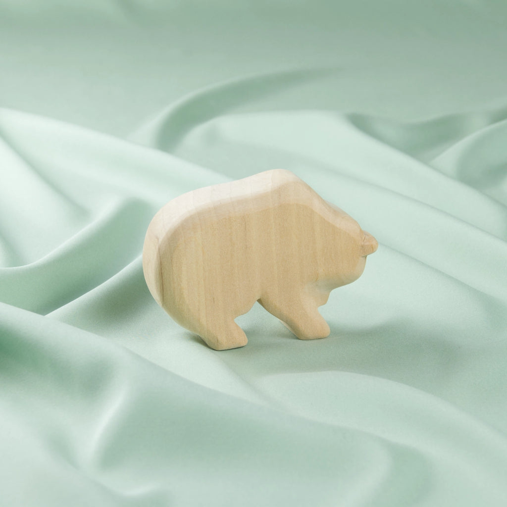 Ein schlichter Holz-Bär in hellem Holz von der Seite