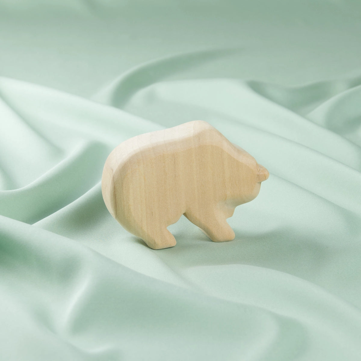 Ein schlichter Holz-Bär in hellem Holz von der Seite
