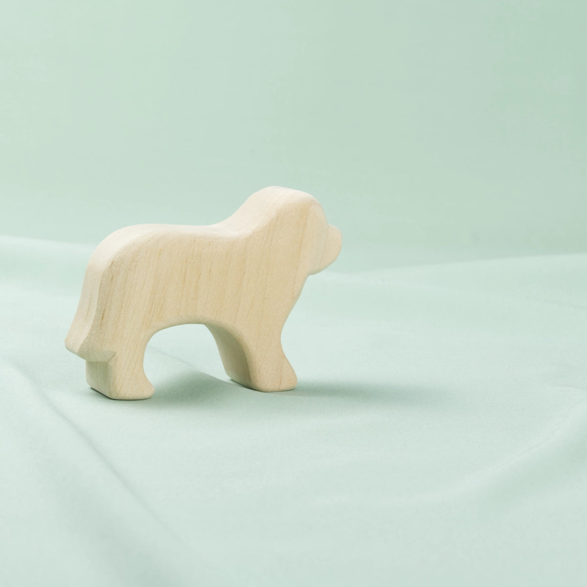 Ein schlichter Holz-Hund in hellem Holz von der Seite