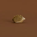 Ein kleiner Igel von Ostheimer aus Naturholz gefertigt, schaut im Profil nach rechts, hat dunkelbraune Stacheln und naturfarbenes Bauchfell.