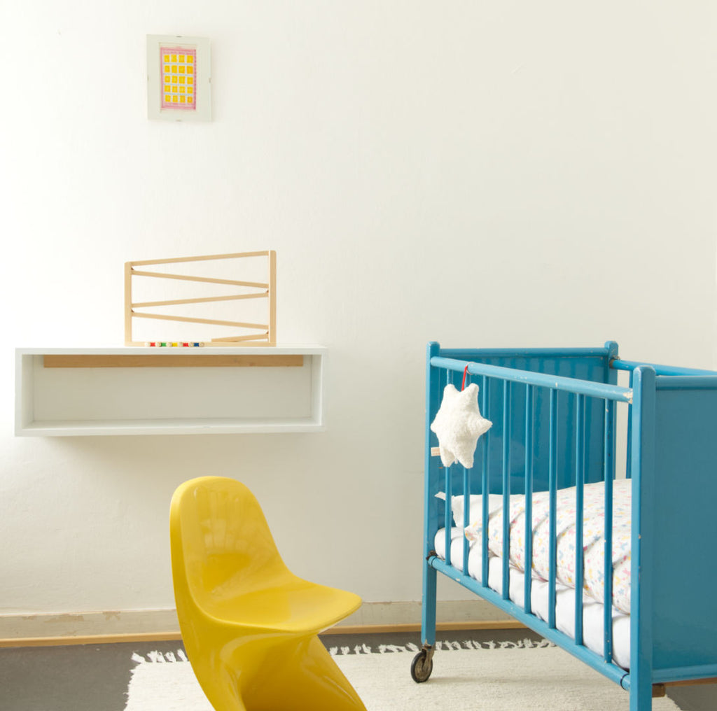 Einblick in ein Kinderzimmer. Zu sehen sind eine Holzbahn und eine weiße Spieluhr in Sternenform.