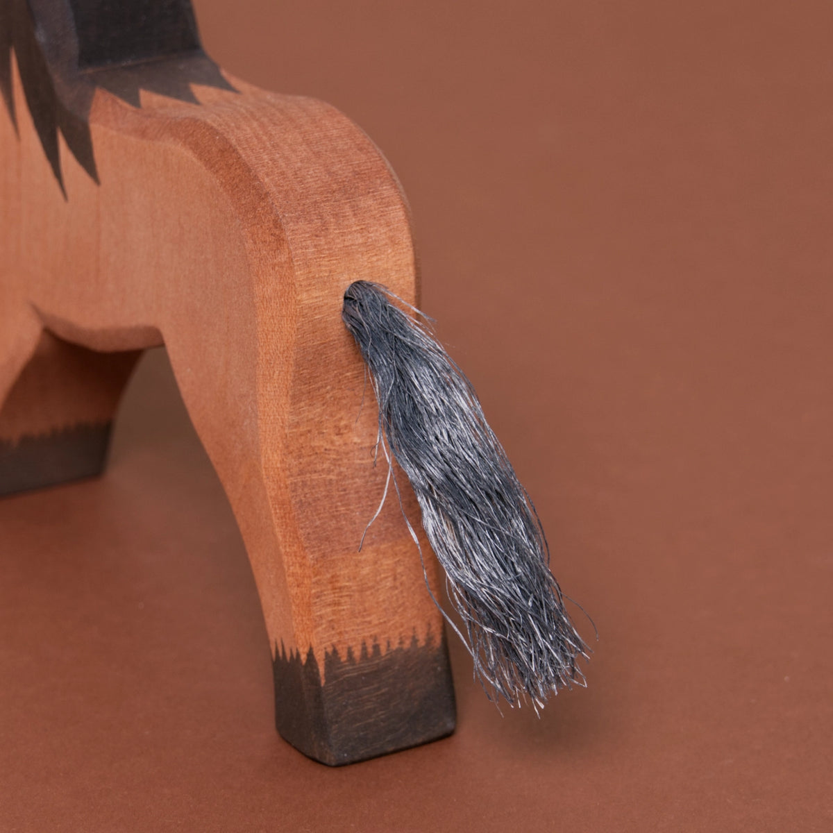 Detailaufnahme des Schweifs aus Naturhaar eines Kaltblutpferdes mit braunem Fell und dunkelbraunen Hufen und Mähne von Ostheimer.