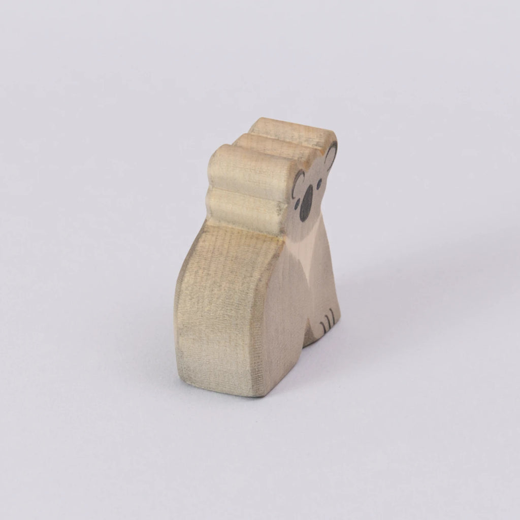 Ein Koala von Ostheimer, aus Holz zum Spielen, in den Farben grau und schwarz für das Gesicht. Der Koala wird schräg von der Seite gezeigt.