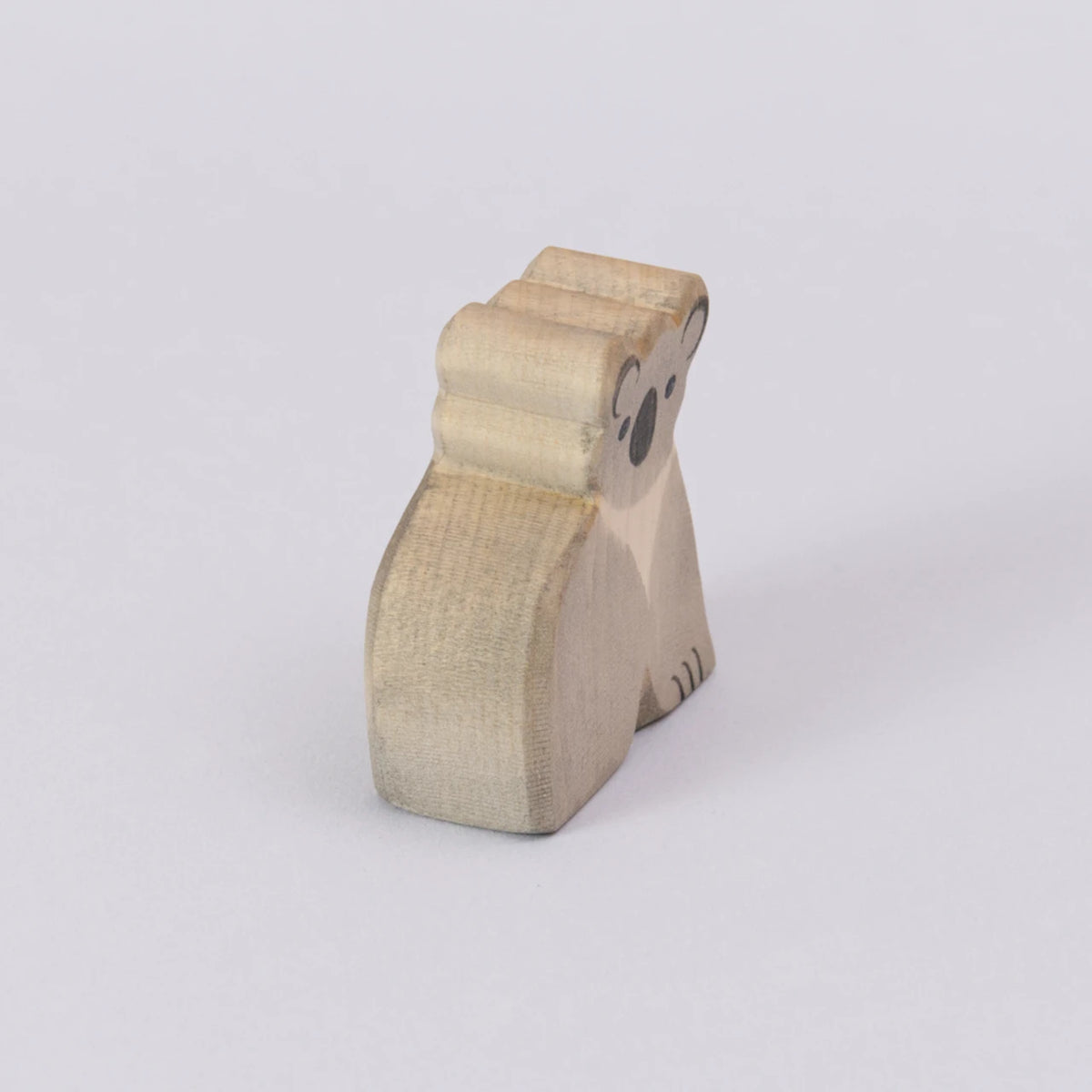 Ein Koala von Ostheimer, aus Holz zum Spielen, in den Farben grau und schwarz für das Gesicht. Der Koala wird schräg von der Seite gezeigt.