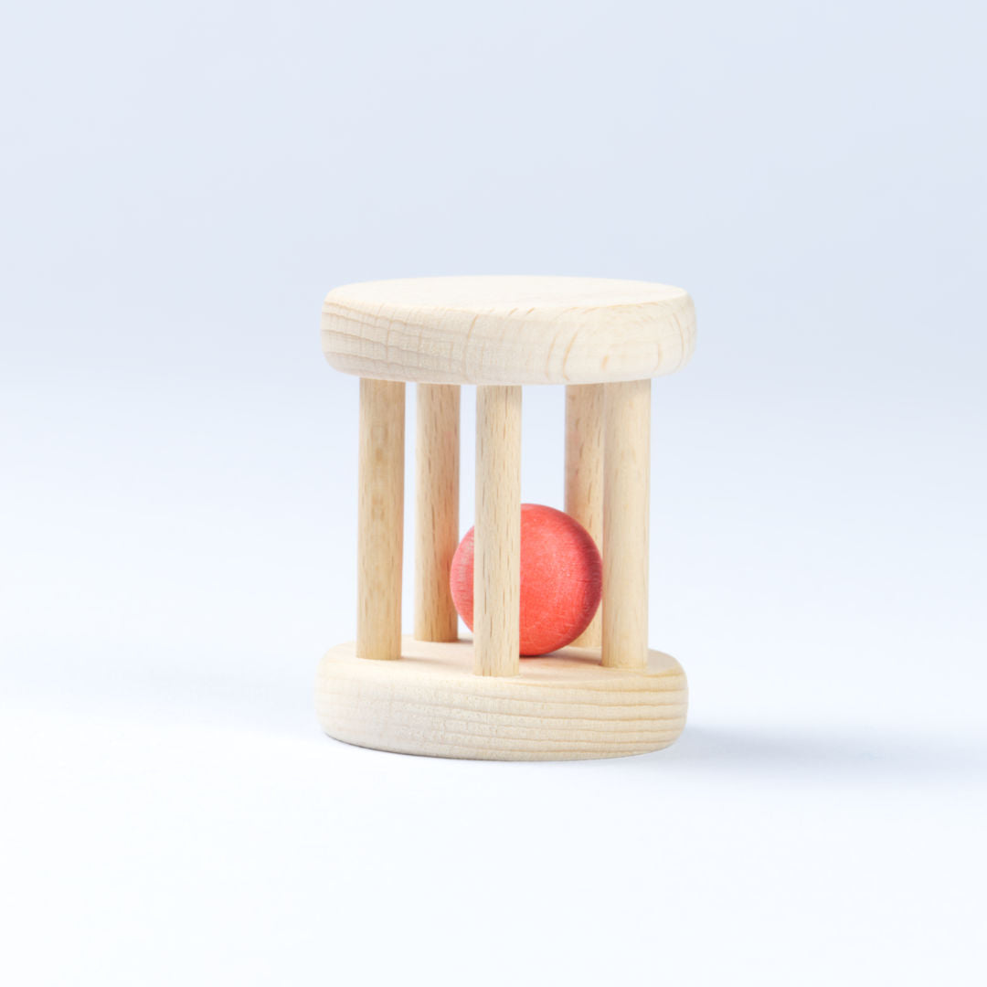 Helle, stehende Kugelrollen Rassel mit einem roten Ball, beides aus Bio Holz.