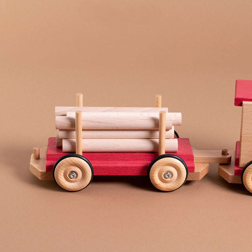 An die Eisenbahn angehängte, rollbare Langholzwagen von Beck. Die Holzstäbe sind lose und flexibel einsetzbar.