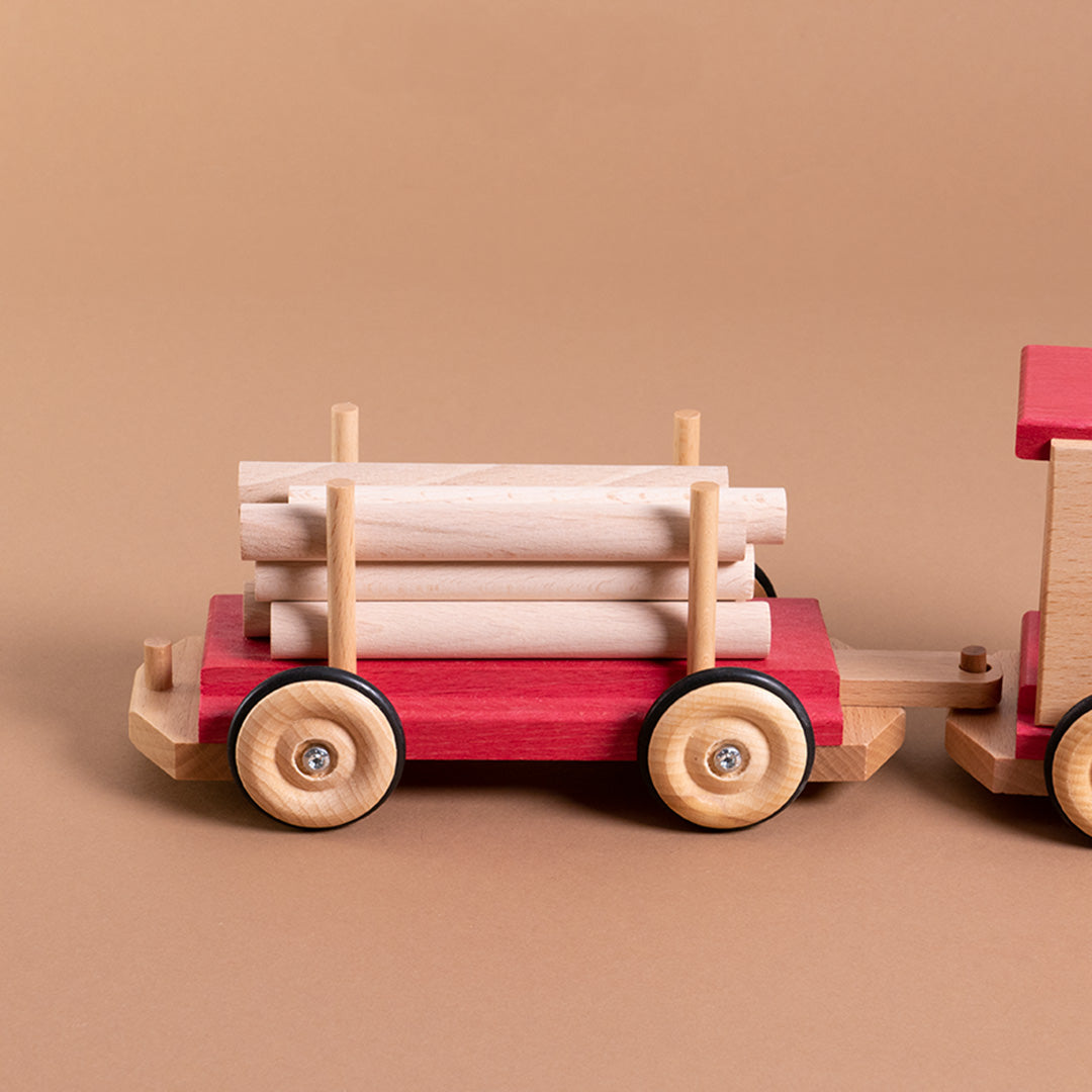 An die Eisenbahn angehängte, rollbare Langholzwagen von Beck. Die Holzstäbe sind lose und flexibel einsetzbar.