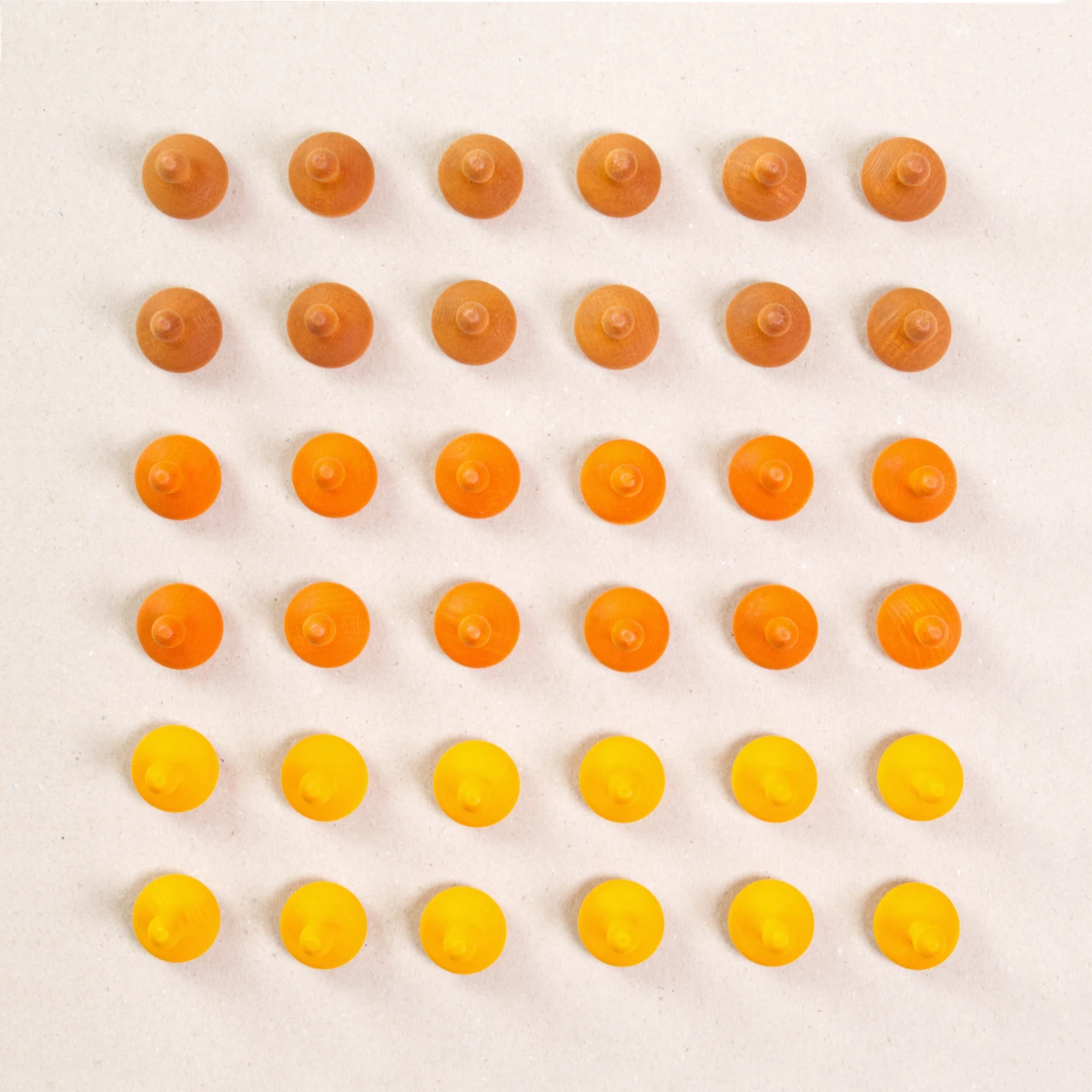 36 Kürbis Holzfiguren von Grapat in drei unterschiedlichen Farben. Hellbraun, orange und gelb. Gemeinsam als Quadratischer Blick aufgebaut. Ansicht von Oben.