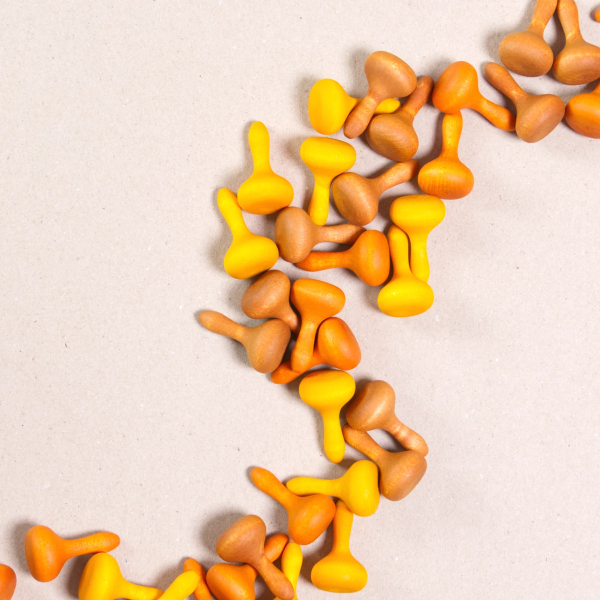 Komposition aus den Figuren aus dem Set Mandala pumpkin von Grapat. Alle Holzfiguren sind orange, braun und gelb.